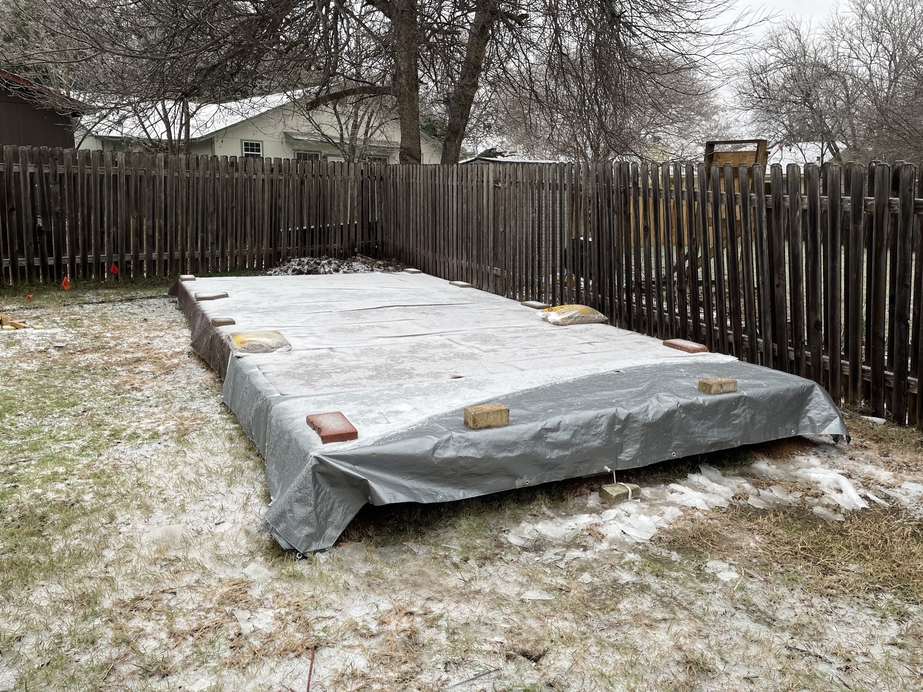 Snow covered tarp covering building foundation